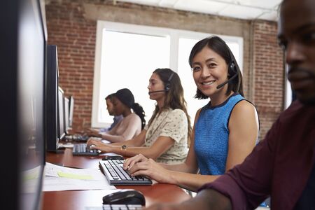 Portrait Of Staff In Busy Customer Service Department Shotの写真素材