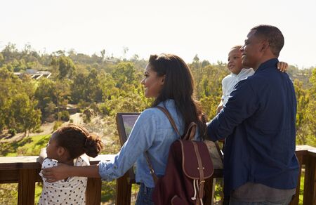 Family Standing On Outdoor Observation Deck Looking At Viewの写真素材