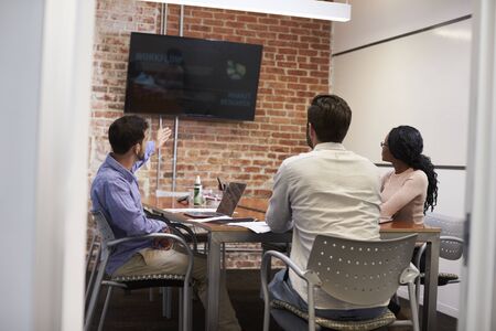 Businesspeople In Meeting Room Looking At Screen