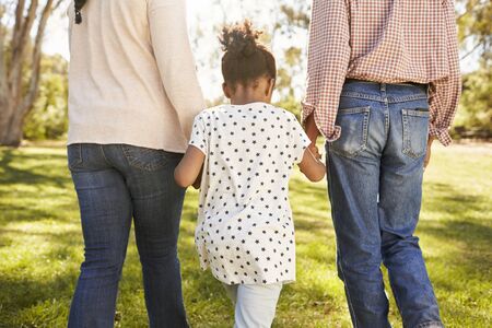 Grandparents And Granddaughter Walking In Park Togetherの写真素材