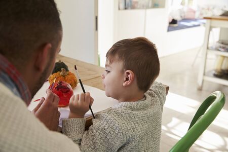 Father And Son Decorating Halloween Pumpkins At Homeの写真素材