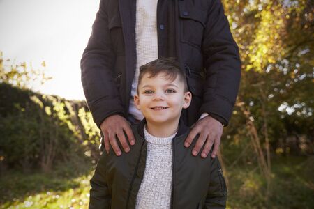 Portrait Of Boy With Father Standing In Autumn Gardenの写真素材