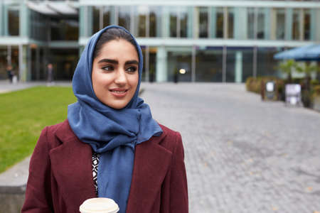 British Muslim Businesswoman With Coffee Outside Officeの写真素材