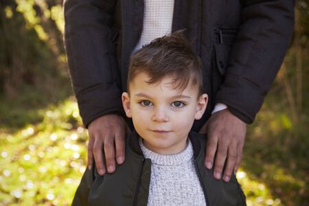 Portrait Of Boy With Father Standing In Autumn Gardenの写真素材