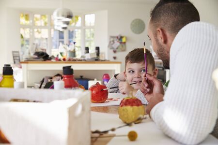 Father And Son Decorating Halloween Pumpkins At Homeの写真素材