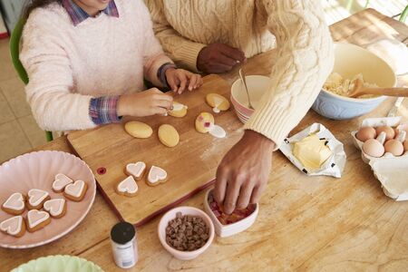 Father And Daughter Decorating Cookies At Home Togetherの写真素材