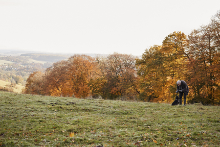 Senior Man Taking Dog For Walk In Autumn Landscapeの写真素材