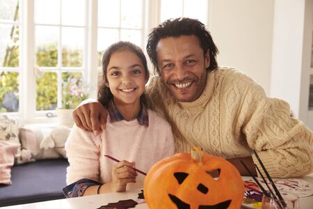 Father And Daughter Making Halloween Decorations At Homeの写真素材