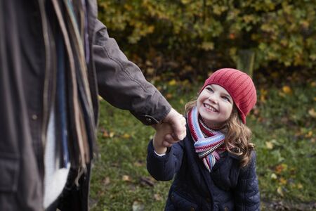 Grandfather And Granddaughter Enjoying Autumn Walkの写真素材