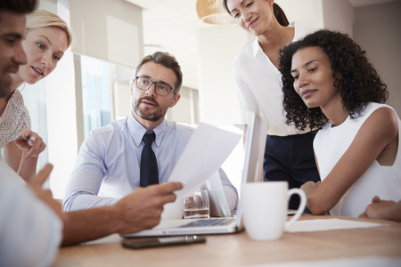 Group Of Businesspeople Meeting Around Table In Office