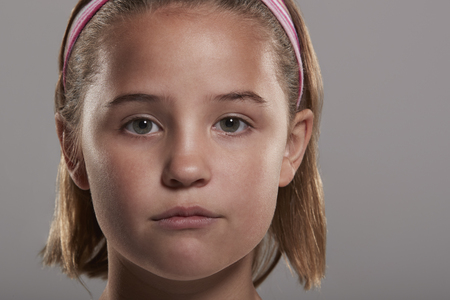 Nine year old girl looking to camera, close up head shotの写真素材