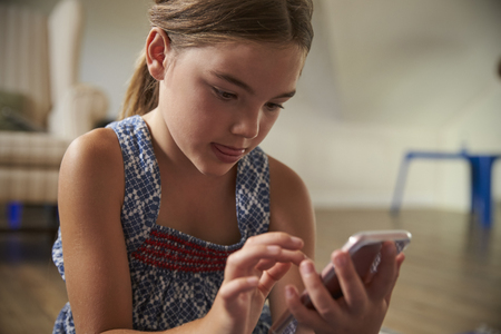 Girl Using Mobile Phone In Playroomの写真素材