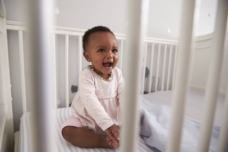 Happy Baby Girl Playing In Nursery Cotの写真素材