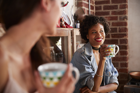Girlfriends hang out in kitchen, close up, selective focusの写真素材
