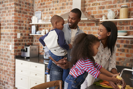 Children Helping Parents To Prepare Meal In Kitchenの写真素材
