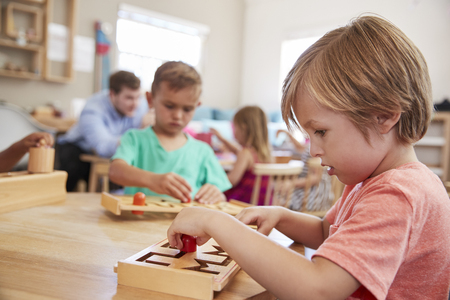 Female Pupil Working At Table In Montessori Schoolの写真素材