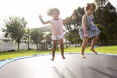 Children At Montessori School Having Fun On Outdoor Trampolineの写真素材