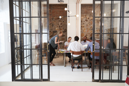 Young woman managing a team meeting in a boardroomの写真素材