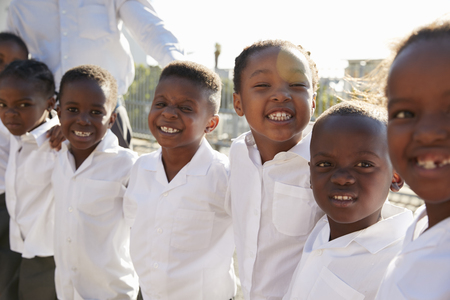 Elementary school kids smiling to camera in playgroundの写真素材
