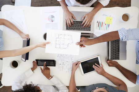 Business people at meeting passing document, overhead shotの写真素材