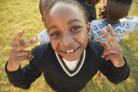 Elementary school girl posing to camera outdoors, high angleの写真素材