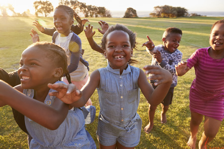 Elementary school kids running to camera outdoors, close upの写真素材