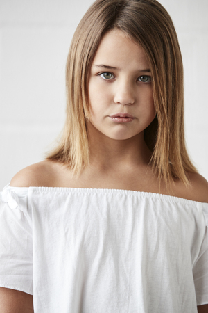 Portrait Of Stylish Young Girl Posing In Studio Against Whiteの写真素材