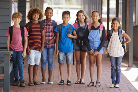 Portrait of kids standing in elementary school hallwayの写真素材