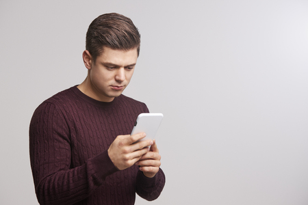 Portrait of a young white man using a smartphoneの写真素材