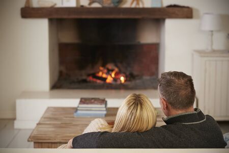 Romantic Couple Relaxing In Lounge Next To Open Fireの写真素材