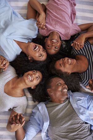 Overhead View Of Family With Teenage Children Lying On Bedの写真素材
