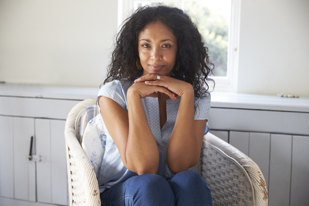 Portrait Of Woman Sitting In Chair At Homeの写真素材