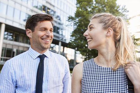 Businesspeople Walking Past Modern City Offices On Way To Work