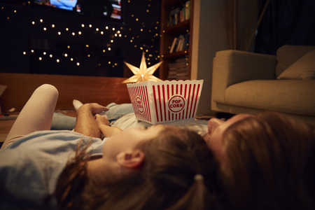 Father And Daughter Enjoying Movie Night At Home Togetherの写真素材