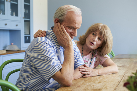 Senior Woman Comforting Man With Depression At Homeの写真素材