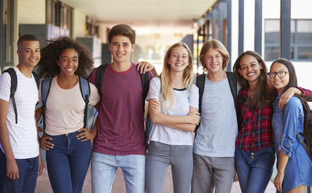 Teenage classmates standing in high school hallwayの写真素材