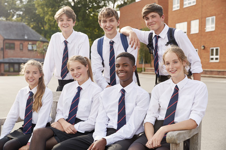 Portrait Of Teenage Students In Uniform Outside School Buildings