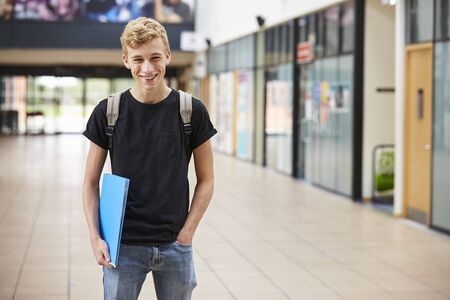 Portrait Of Male Student Standing In College Buildingの写真素材