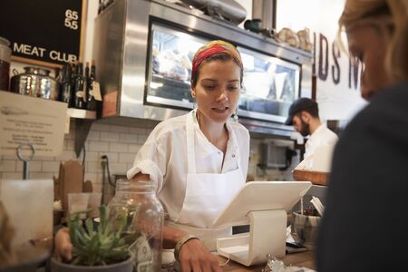 Young woman serving a customer in a butcher's shop