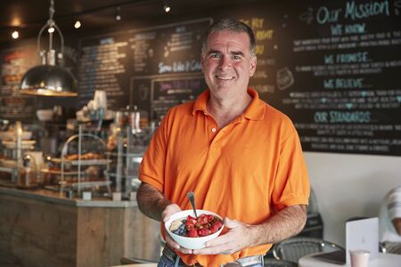 Mature Man Holding Healthy Breakfast In Coffee Shopの写真素材