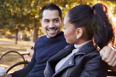 Young couple sitting on bench in Brooklyn park, close upの写真素材
