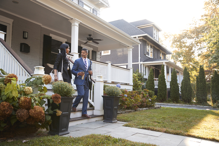 Business Couple Leaving Suburban House For Commute To Workの写真素材