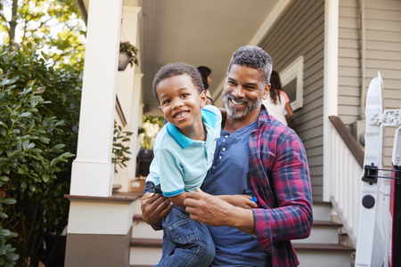 Children Helping Children With Boxes On Moving In Dayの写真素材