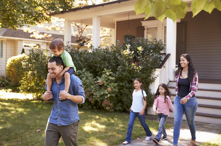 Father Gives Son Ride On Shoulders As Family Leave Houseの写真素材