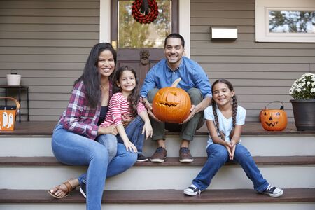 Portrait Of Family Carving Halloween Pumpkin On House Stepsの写真素材