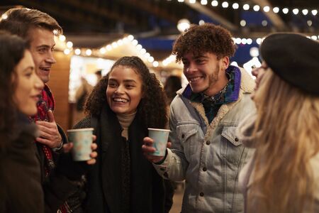Group Of Friends Drinking Mulled Wine At Christmas Marketの写真素材