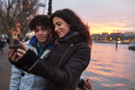Couple Taking Selfie During Walk Along South Bank In Londonの写真素材