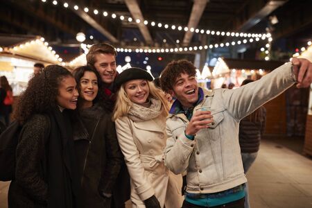 Young Friends Posing For Selfie At Christmas Marketの写真素材