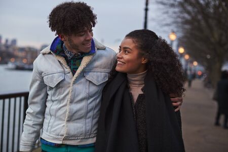 Couple Walking Along South Bank On Winter Visit To London