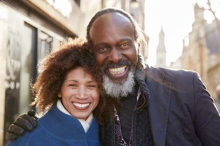 Portrait Of Mature Couple Walking Through City In Fall Togetherの写真素材